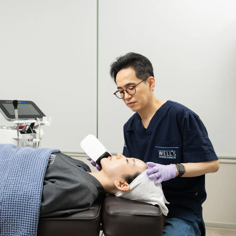 Board-certified dermatologist treating a patient at Wells Clinic